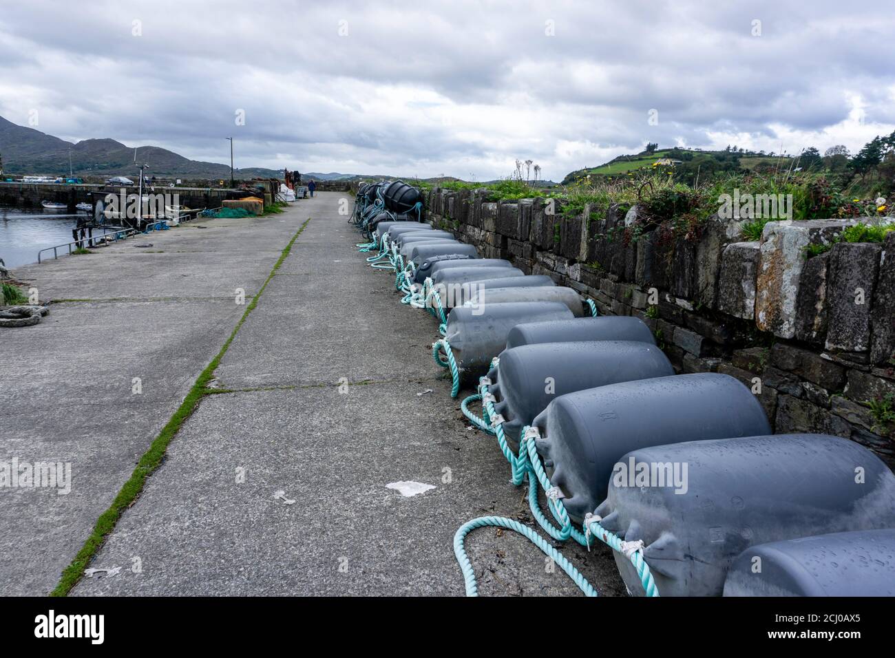 Il piccolo porto di Tuoist, contea di Kerry, Irlanda sulla penisola di Beara con galleggianti di mitili allineati sul molo. Ci sono un certo numero di allevamenti di mitili Foto Stock