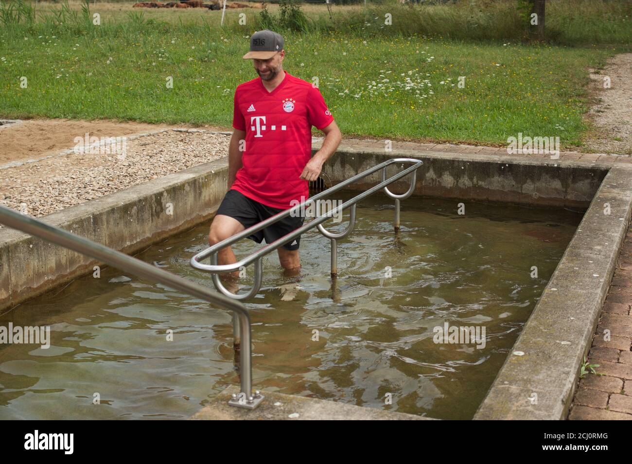 Uomo che guada nella piscina d'acqua fredda kneipp, Franconia, Germania Foto Stock