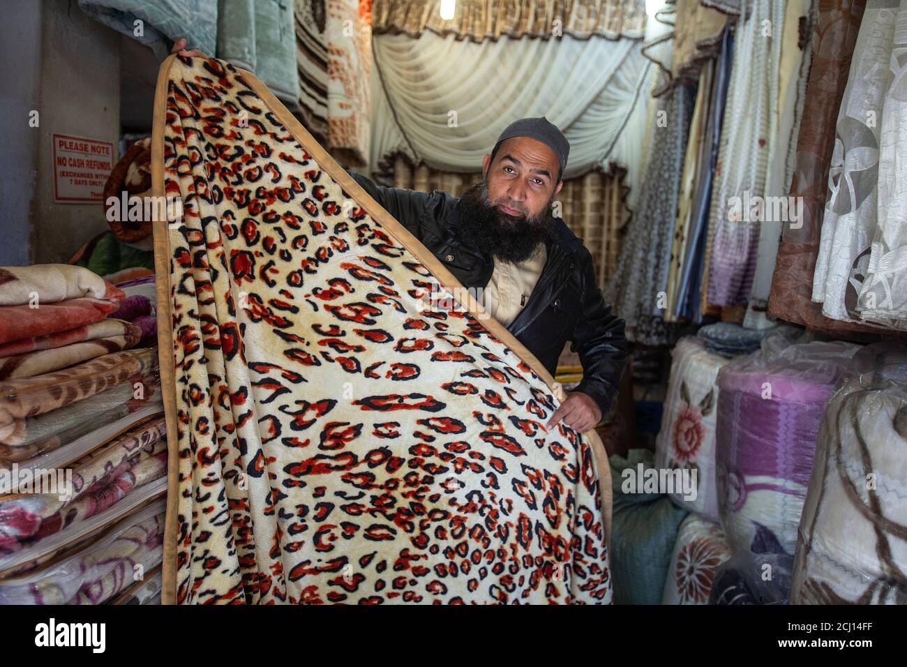 Uomo indiano che vende coperte africane tradizionali a Johannesburg, Sudafrica Foto Stock