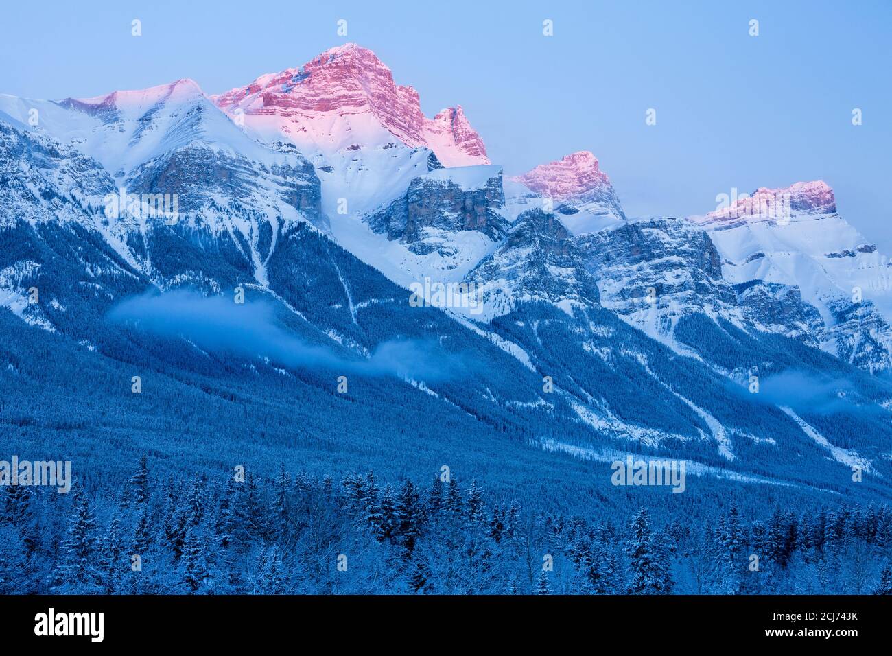 Primo faro sulla vetta innevata di montagna, Canmore, Alberta, Canada Foto Stock