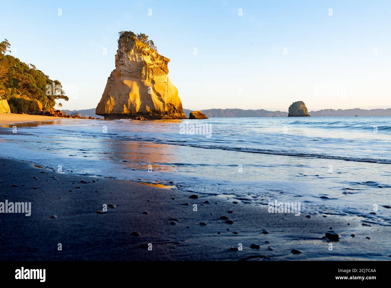 Cattura mattina bagliore pietra arenaria in piedi roccia te Hoho all'alba Cathedral Cove sulla penisola di Coromandel Nuova Zelanda. Foto Stock