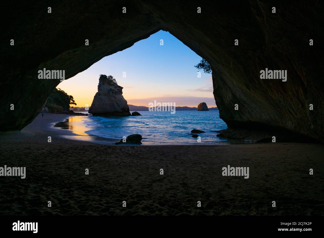 Te Hoho Rock al tramonto incorniciato da una silhouette naturale dell'arco di Cathedral Cove sulla Penisola di Coromandel, Nuova Zelanda. Foto Stock