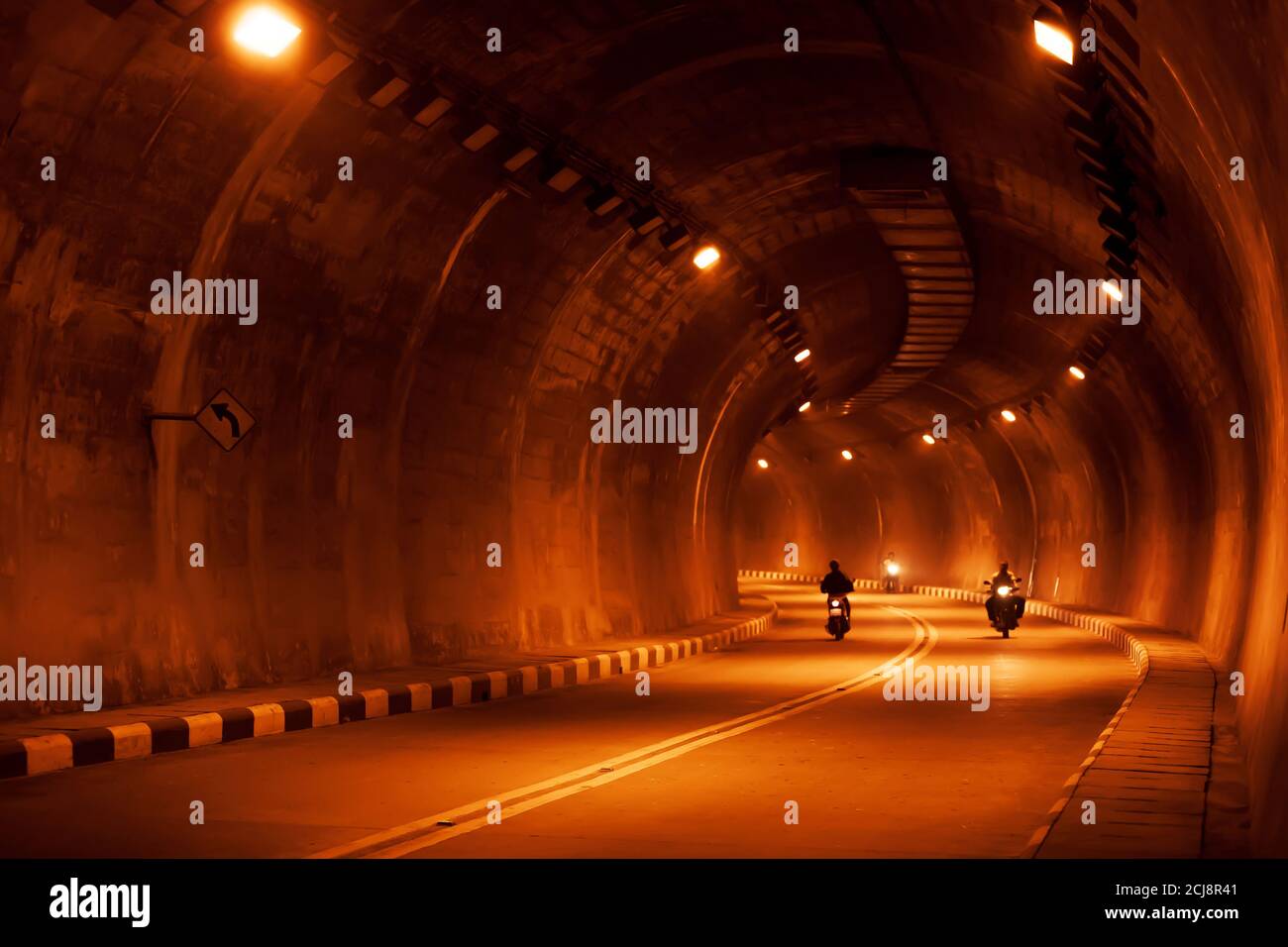 Motion Blur, persone asiatiche che cavalcano moto in un tunnel buio di notte. Foto Stock