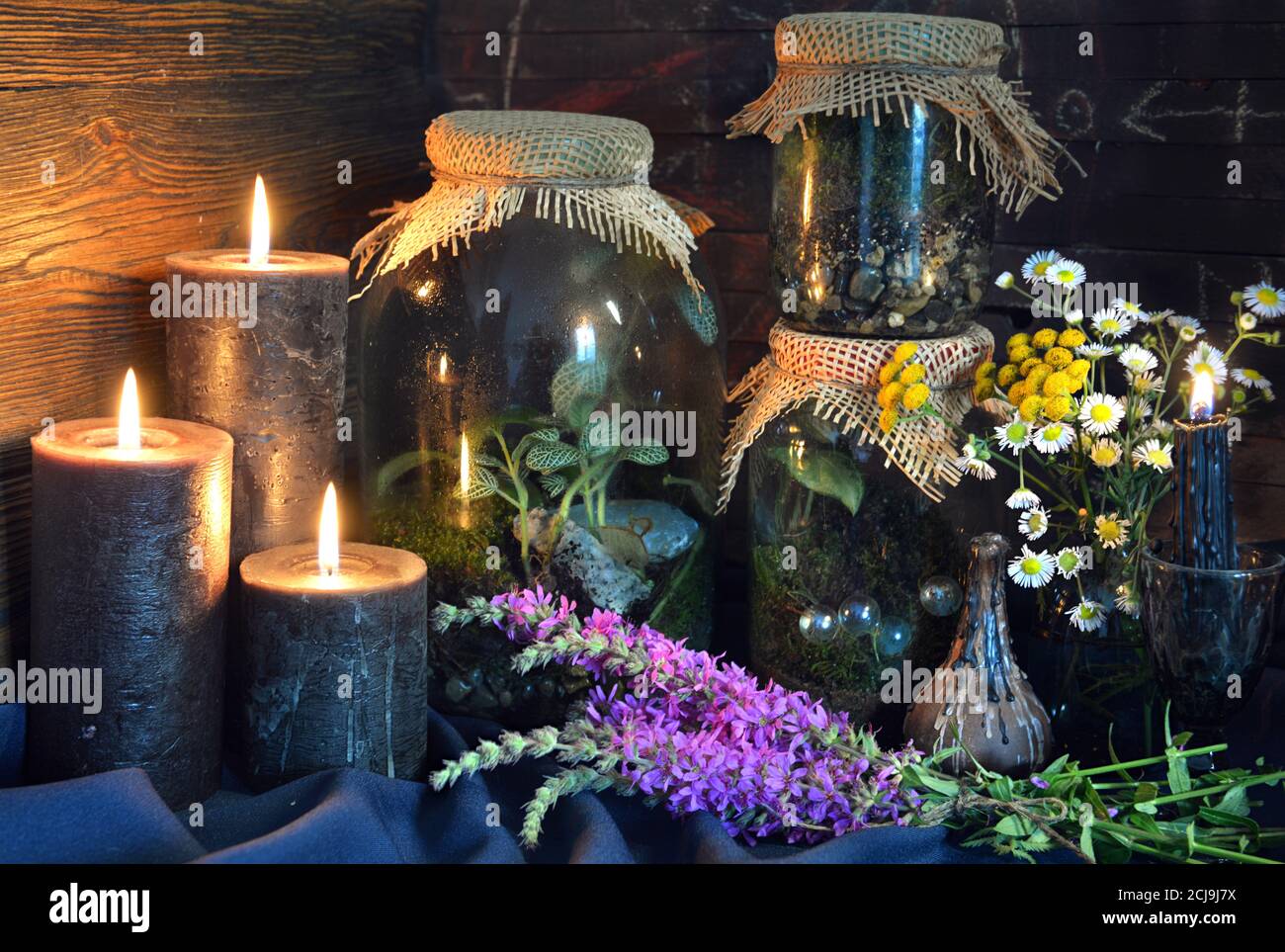Candele nere e bottiglie magiche con piante ed erbe sulla tavola delle  streghe. Sfondo esoterico, gotico e occulto, concetto mistico di Halloween  Foto stock - Alamy
