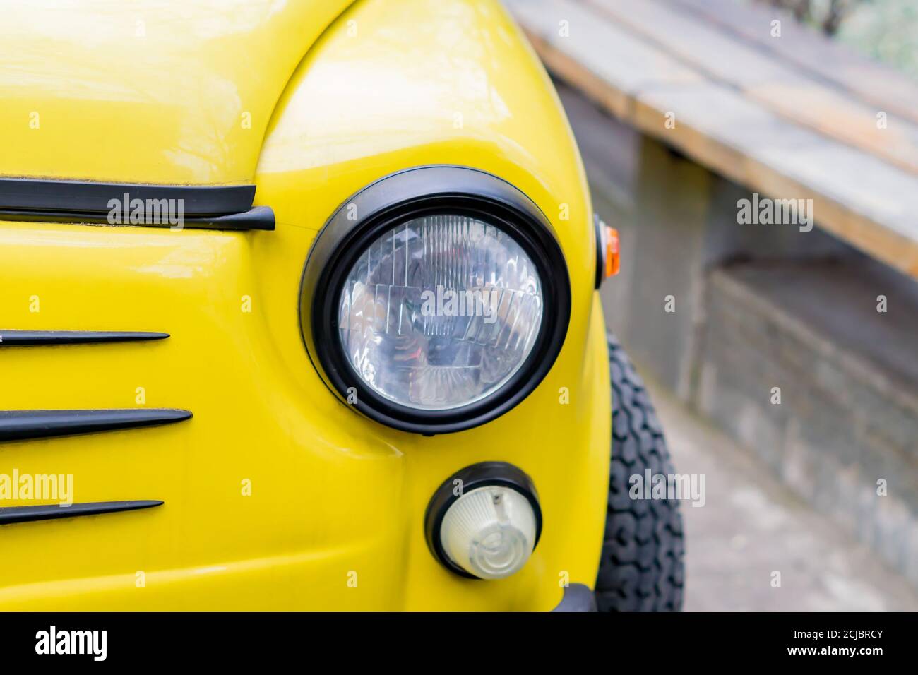 primo piano della vettura retrò gialla con fari rotondi Foto Stock