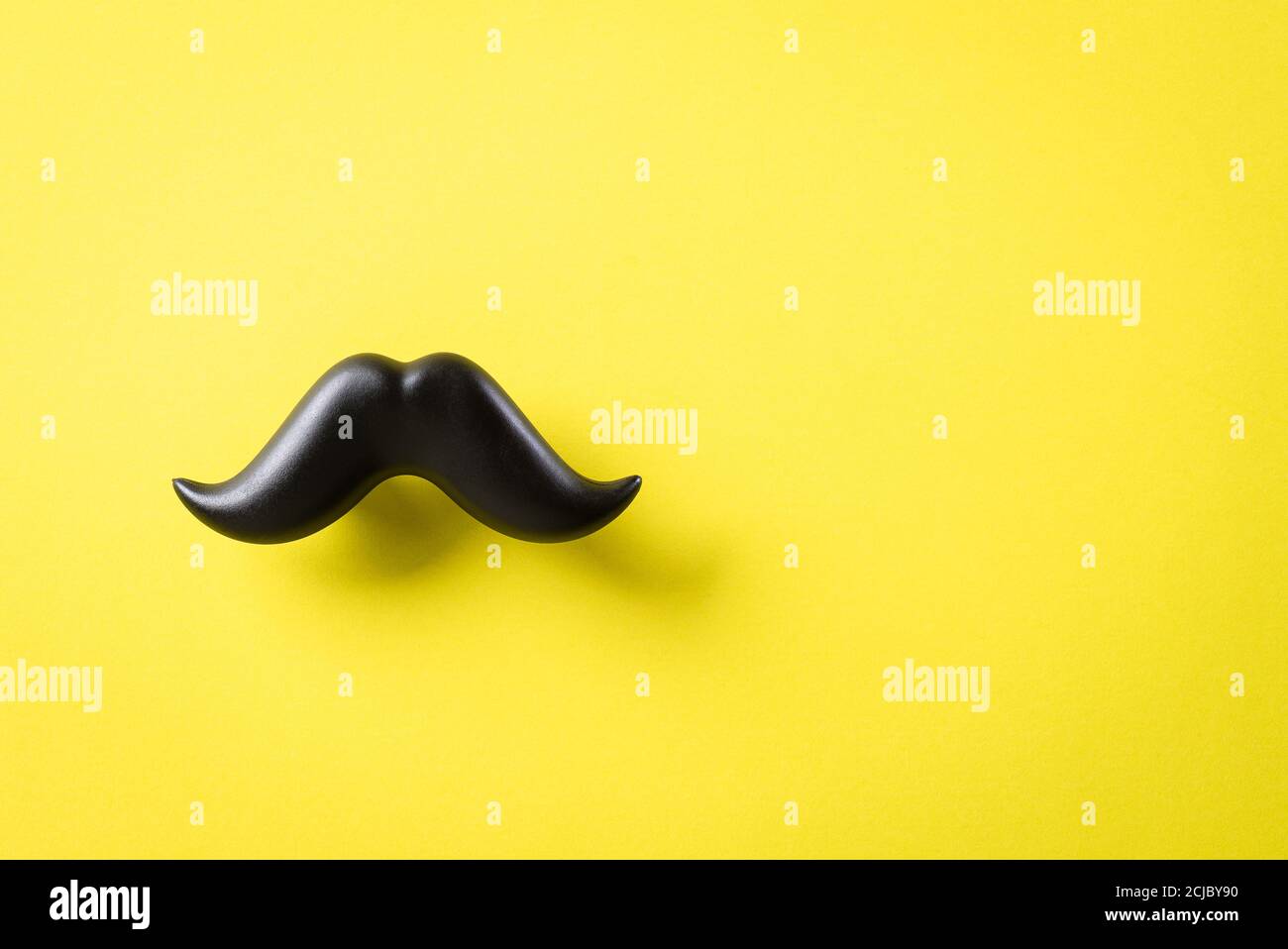 Concetto del giorno del Padre. Baffi neri su sfondo di carta giallo. Foto Stock