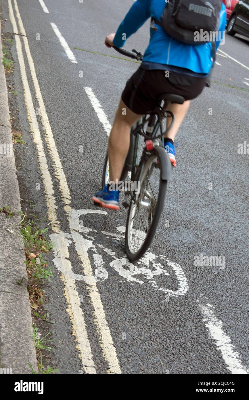 un ciclista maschile che usa una corsia di ciclo di consulenza molto stretta, a barnes, a sud-ovest di londra, in inghilterra Foto Stock