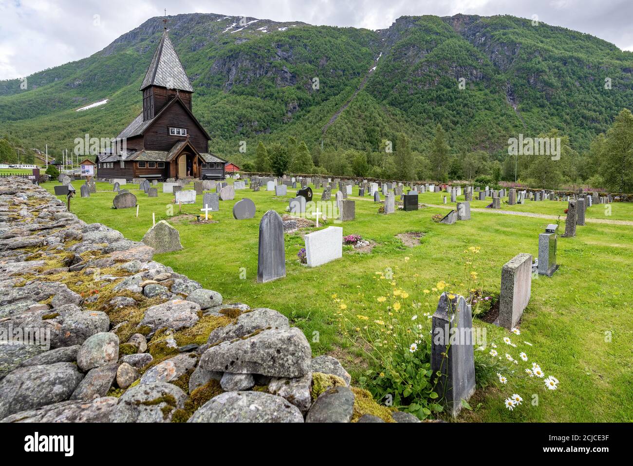 Røldal, Ullensvang, Norvegia - 13 ° secolo Chiesa di legno Roldal Stave (Røldal stavkyrkje) e cimitero in un giorno nuvoloso, Odda, Hordaland Foto Stock