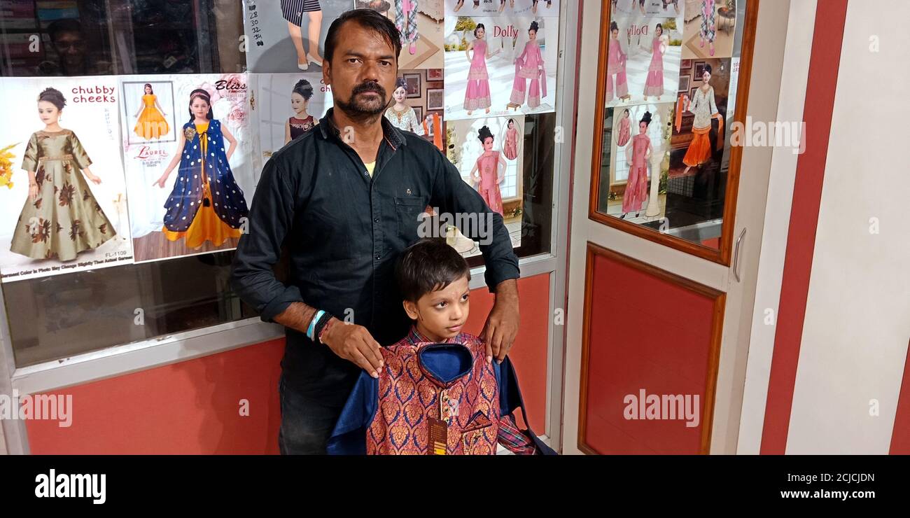 DISTRETTO KATNI, INDIA - 18 SETTEMBRE 2019: Un venditore indiano che vende abiti per bambini al negozio di abbigliamento durante il mercato indiano festival offre la vendita. Foto Stock