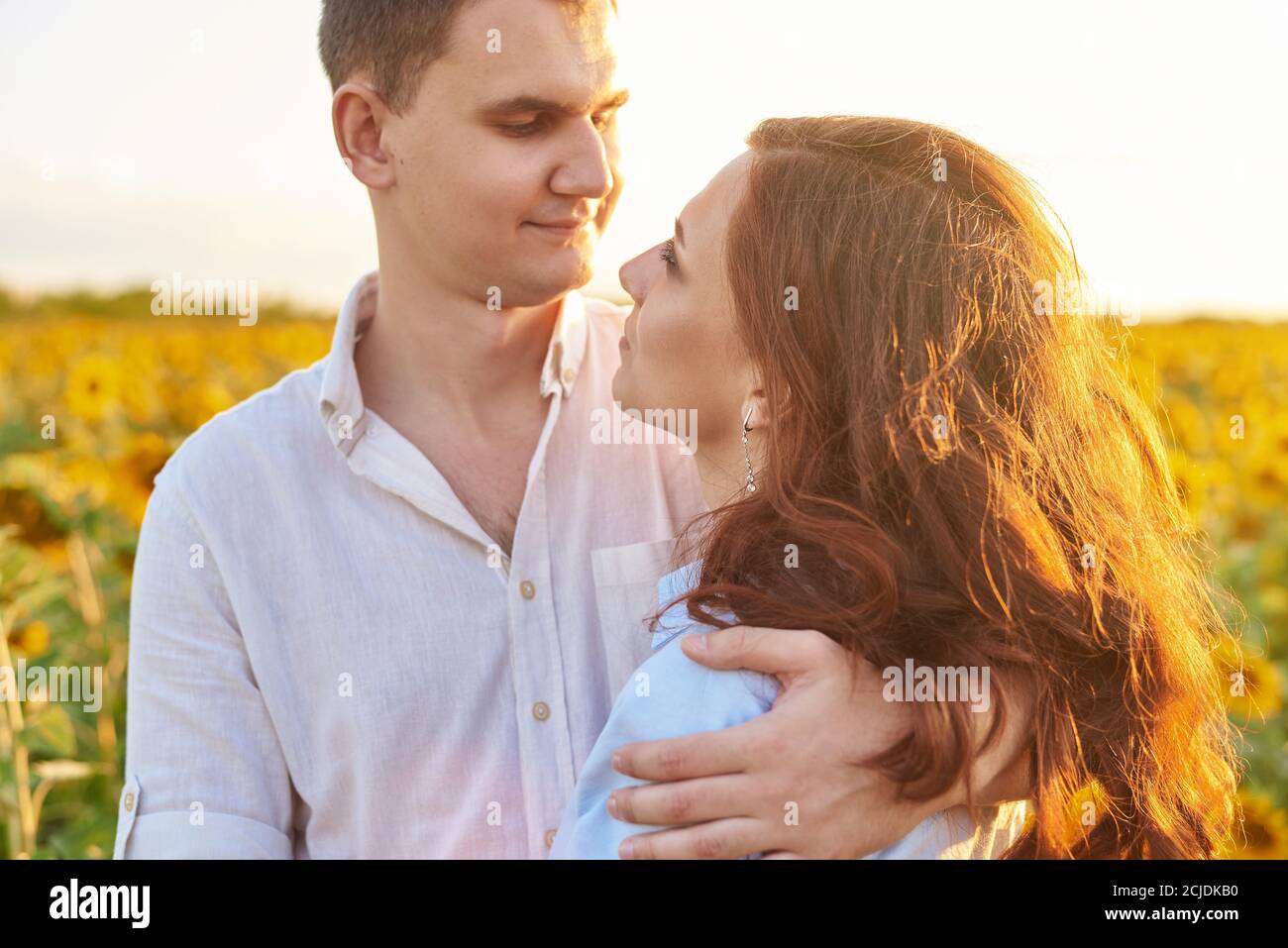 Sorridendo felice coppia newlywed in un campo di girasoli. Il concetto di amore, rispetto reciproco e rapporti giusti. Primo piano. Foto Stock