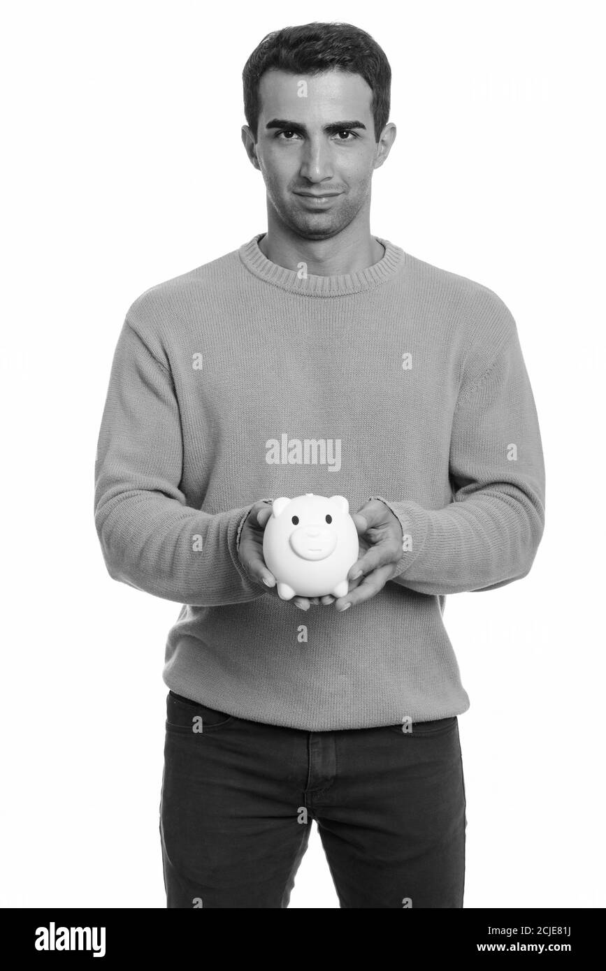 Giovane bell'uomo iraniano che detiene una banca di porcellini Foto Stock