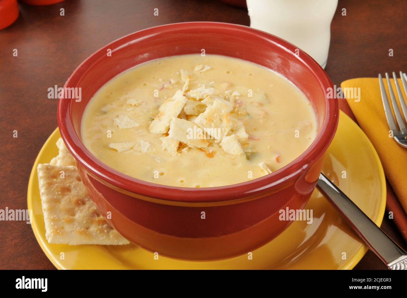 Ciotola di zuppa di pollo con peperoni verdi e rossi, formaggio cheddar e mozzarella Foto Stock