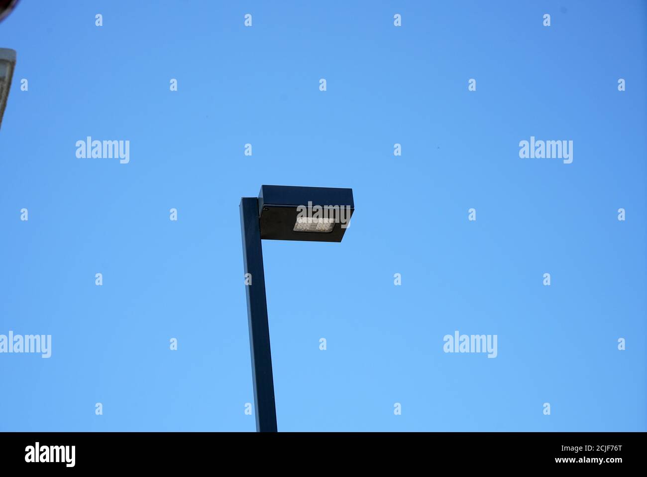 Lampione su un palo contro un cielo blu chiaro Foto Stock