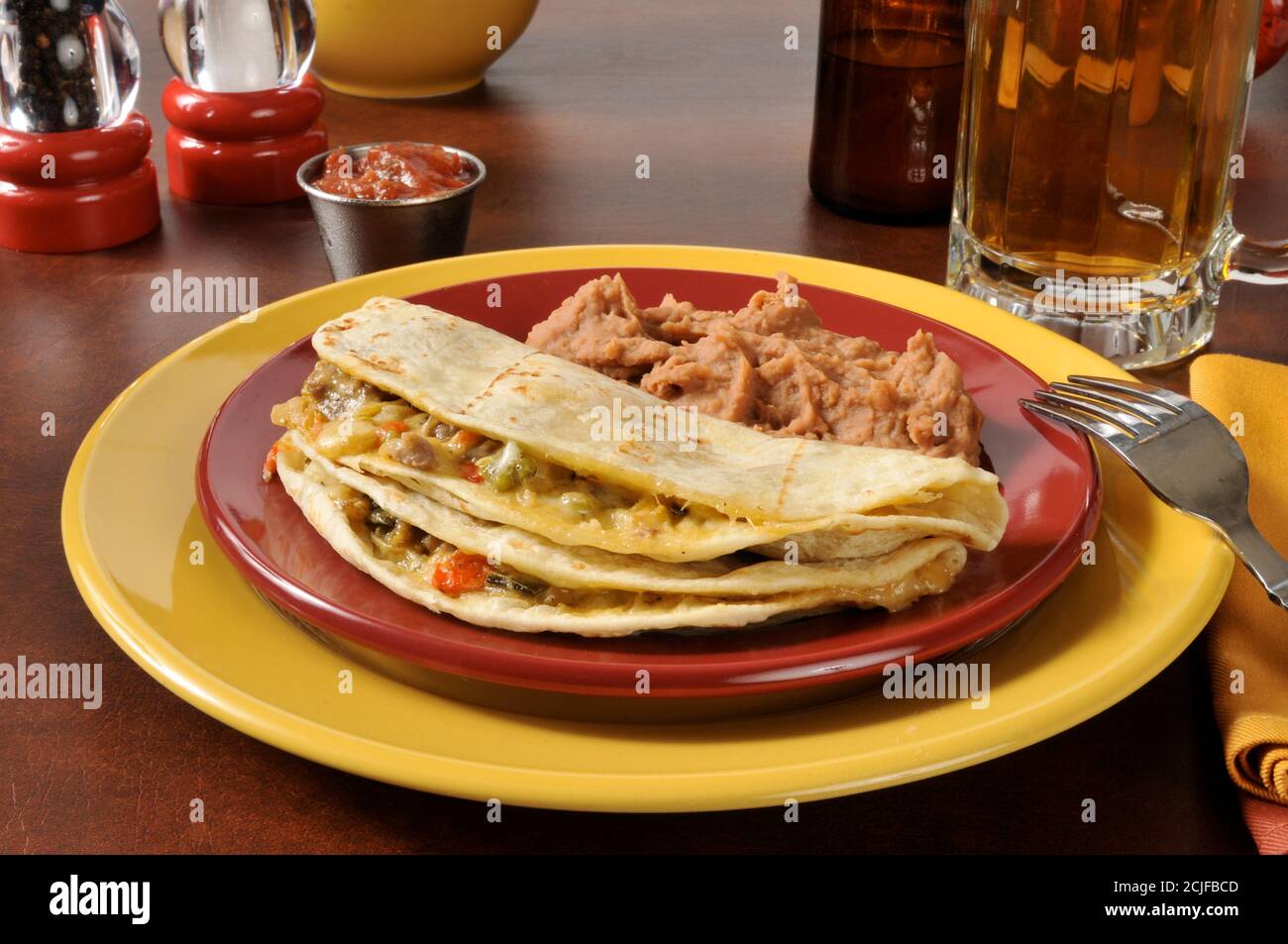 Quesadilla di manzo e formaggio grattugiato con fagioli e birra ghiacciati Foto Stock