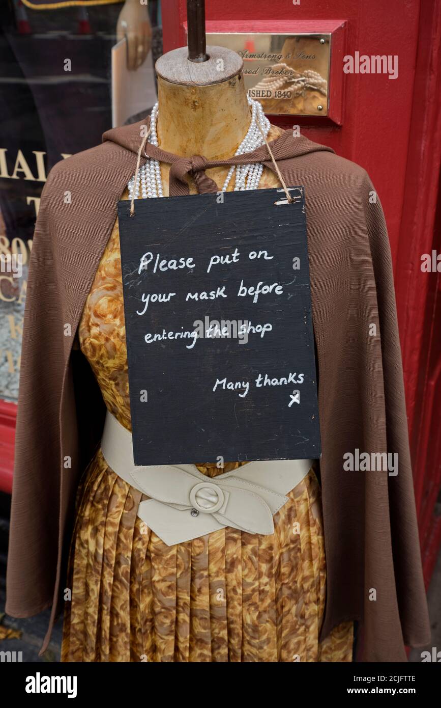 "Indossa la maschera prima di entrare nel negozio", all'esterno del negozio di abbigliamento d'epoca Armstrongs nel Grassmarket, Edimburgo, Scozia, Regno Unito. Foto Stock