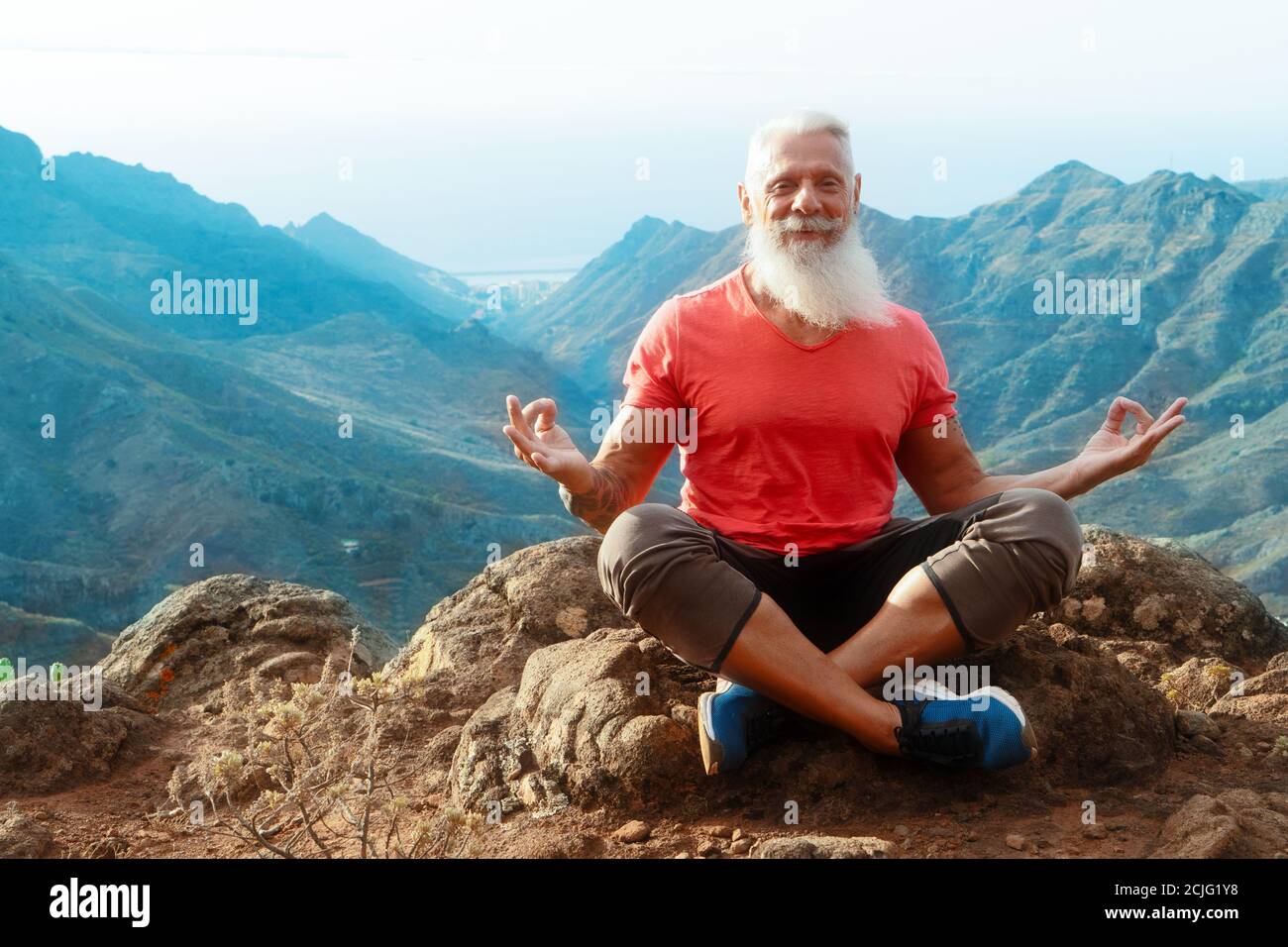 Uomo anziano saluto tramonto Foto Stock