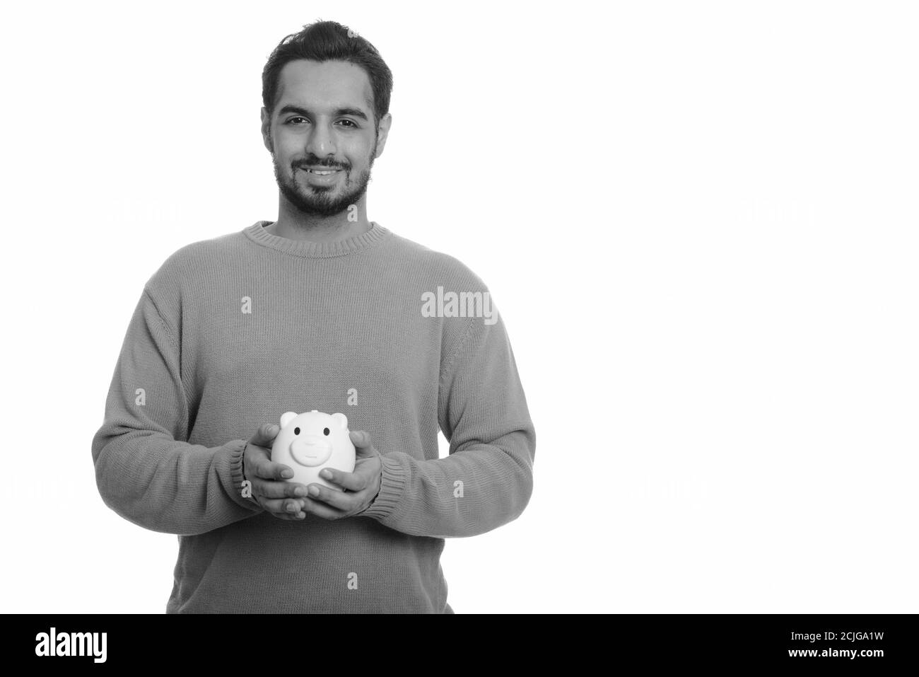 Giovani felici uomo indiano holding salvadanaio Foto Stock