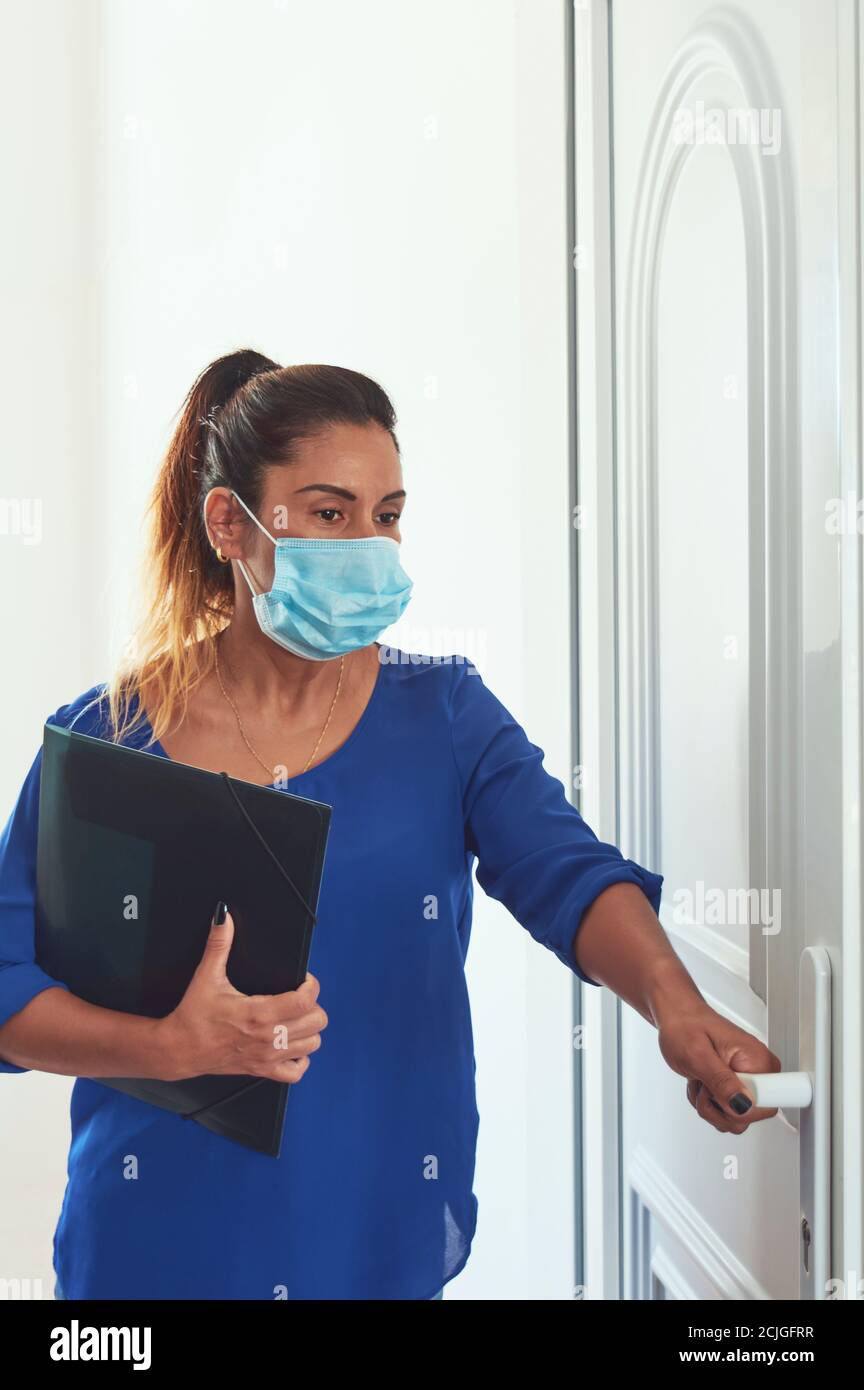 Donna latina, di mezza età che si prepara a lavorare nella nuova normalità, Foto Stock