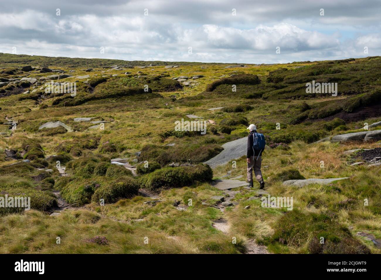 Walker sulle remote brughiere di Fairbrook Naze su Kinder Scout, Peak District, Derbyshire, Inghilterra. Foto Stock