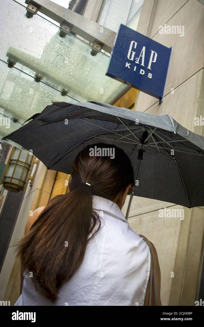 Una donna che porta un ombrello passa da un negozio Gap sulla 5th avenue  nel centro di Manhattan a New York il 16 giugno 2015. Il rivenditore di abbigliamento  Gap Inc ha