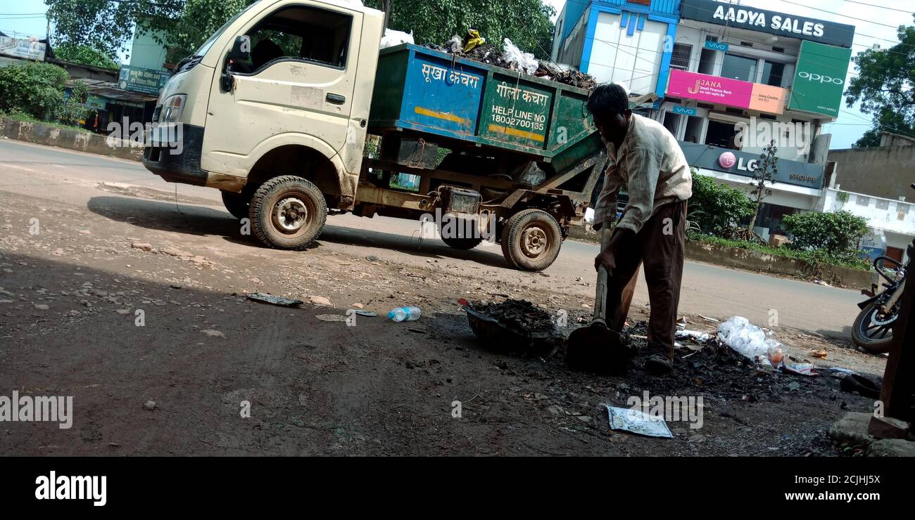 DISTRETTO KATNI, INDIA - 05 SETTEMBRE 2019: Indiano società comunale spazzatrice pulizia lato strada grondaia. Foto Stock