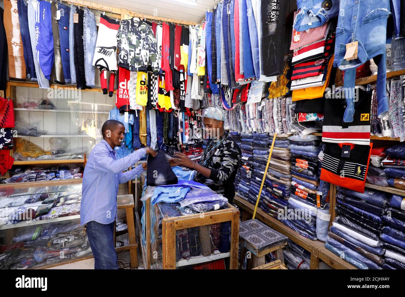 Un uomo somalo acquista vestiti importati, mentre i produttori tradizionali  somali lottano per preservare una tradizione somala che è minacciata da  un'ondata di vestiti economici importati dalla Cina e da altri paesi,