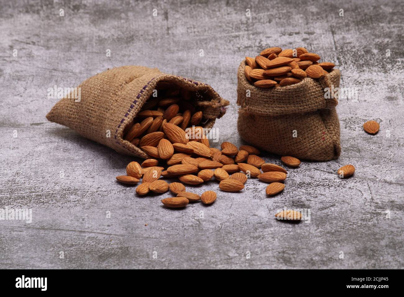 Mandorle in sacchetto isolate su sfondo grigio. Foto Stock