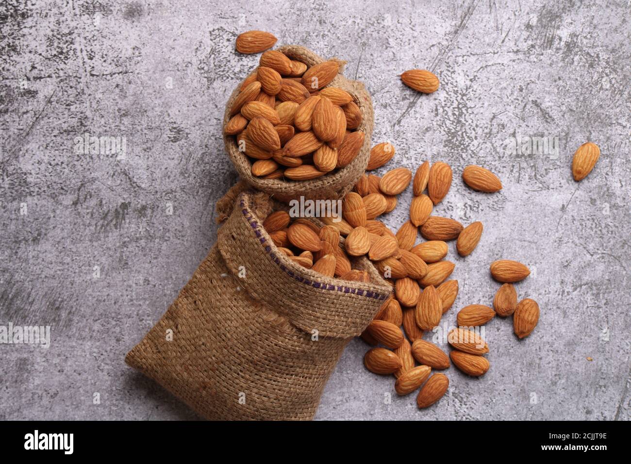 Mandorle in sacchetto isolate su sfondo grigio. Foto Stock