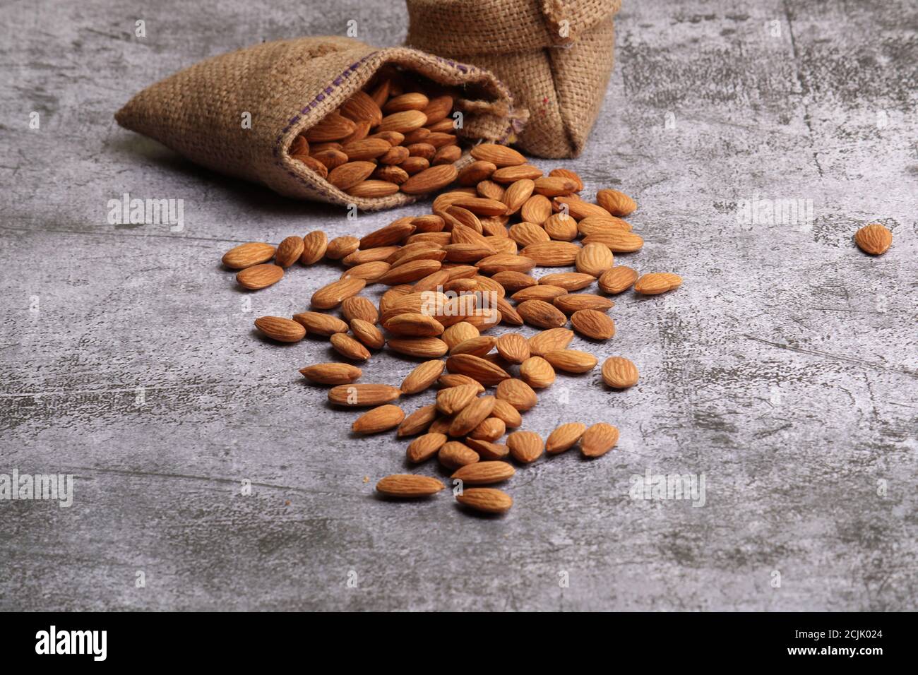 Mandorle in sacchetto isolate su sfondo grigio. Foto Stock