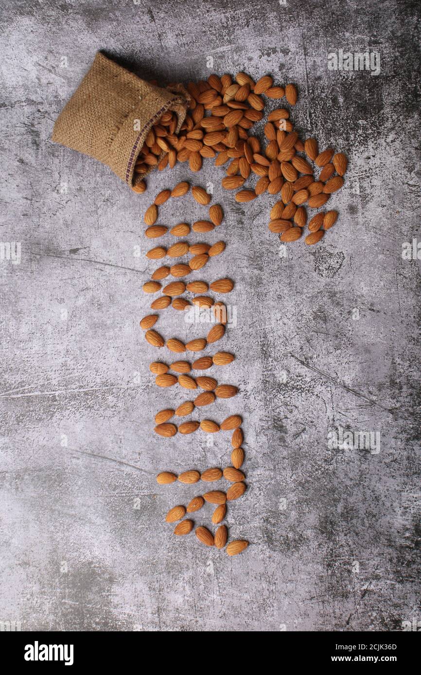 Mandorle in sacchetto isolate su sfondo grigio. Foto Stock