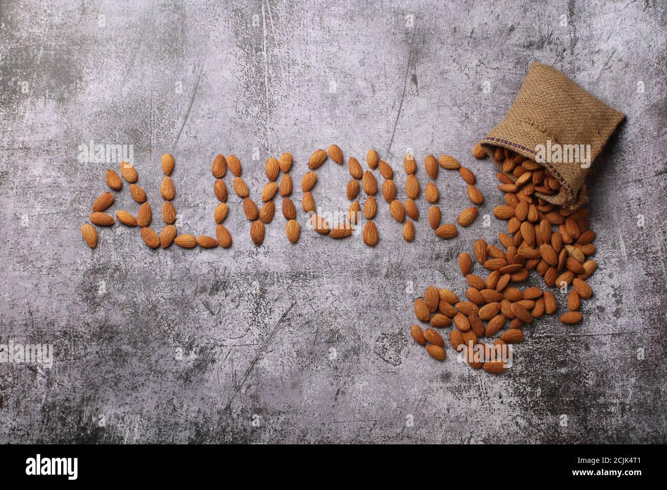 Mandorle in sacchetto isolate su sfondo grigio. Foto Stock