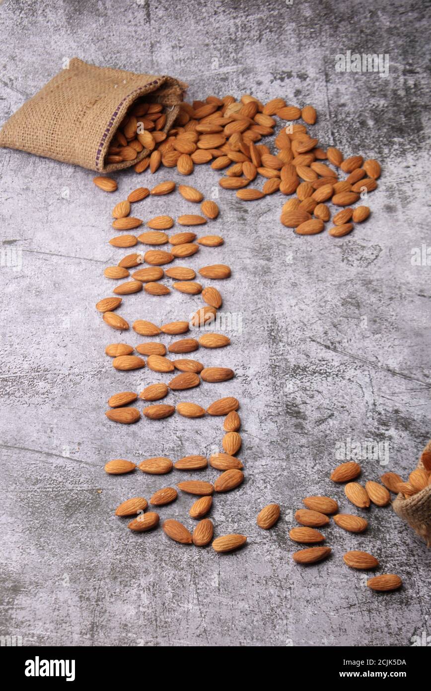 Mandorle in sacchetto isolate su sfondo grigio. Foto Stock