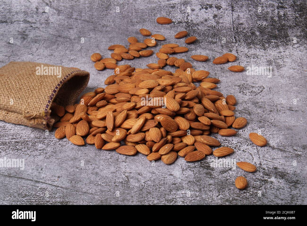 Mandorle in sacchetto isolate su sfondo grigio. Foto Stock