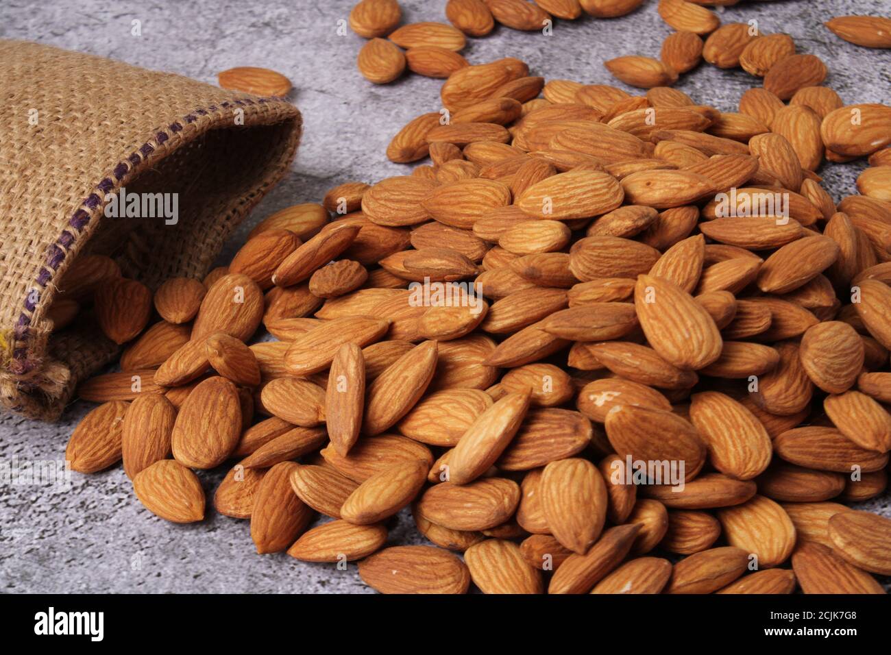 Mandorle in sacchetto isolate su sfondo grigio. Foto Stock
