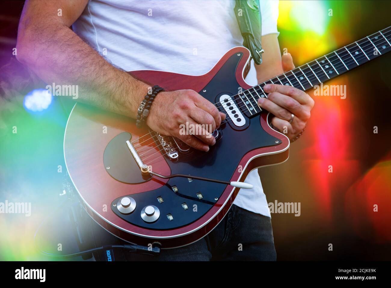 Chitarrista sul palco con effetti di luce. Primo piano con la chitarra. Giovane musicista che suona la chitarra, sottofondo musicale dal vivo. Band che suona sul palco, musica rock Foto Stock