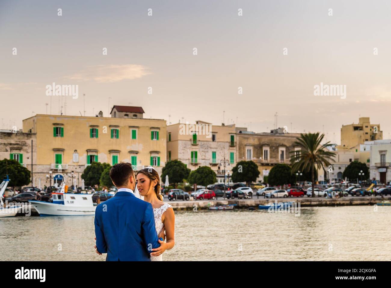 MOLFETTA (BA), 31 AGOSTO 2020: Gli sposi novelli baciano sotto il tramonto sul mare di ​​Molfetta Foto Stock