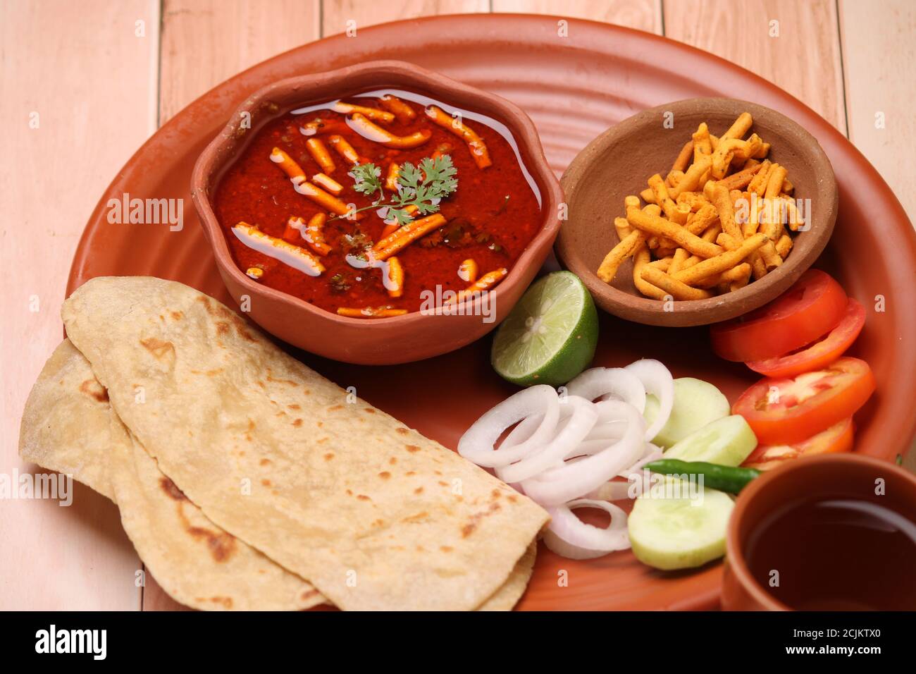 Dhaba Style Sev bhaji/sabzi/curry fatto con curry di pomodoro con shev gathiya, servito con chapati/roti. Foto Stock