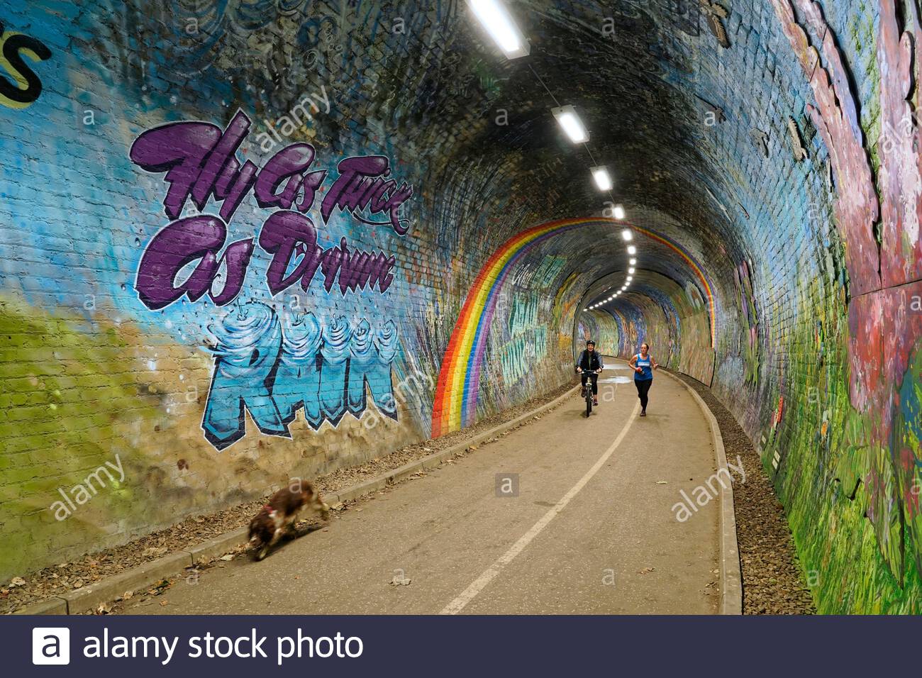 Edimburgo, Scozia, Regno Unito. 15 settembre 2020. Le persone che si godono la passeggiata lungo il fiume sull'acqua di Leith passano attraverso il tunnel Colinton, un tunnel ferroviario vittoriano che è stato decorato con il più grande murale storico della Scozia, basato su una breve storia di Robert Louis Stevenson e che celebra la storia industriale, sociale, artistica e letteraria della zona. Il murale dovrebbe essere completato nel mese di settembre. Credit: Craig Brown/Alamy Live News Foto Stock