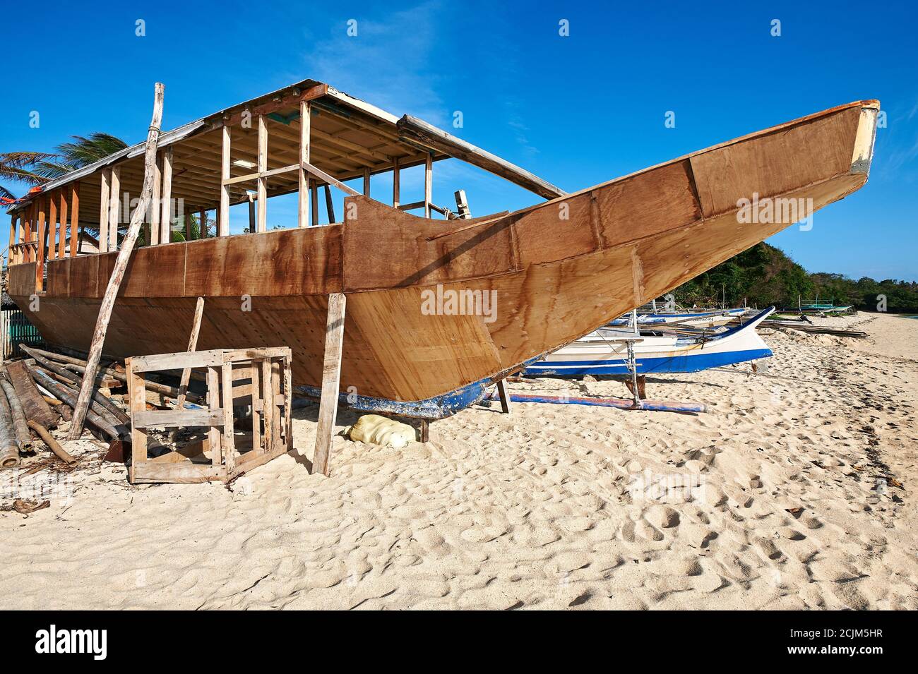 Un'imbarcazione in legno di stile filippino banca è in fase di costruzione lungo una spiaggia di sabbia sull'isola di Boracay, Filippine, Asia Foto Stock