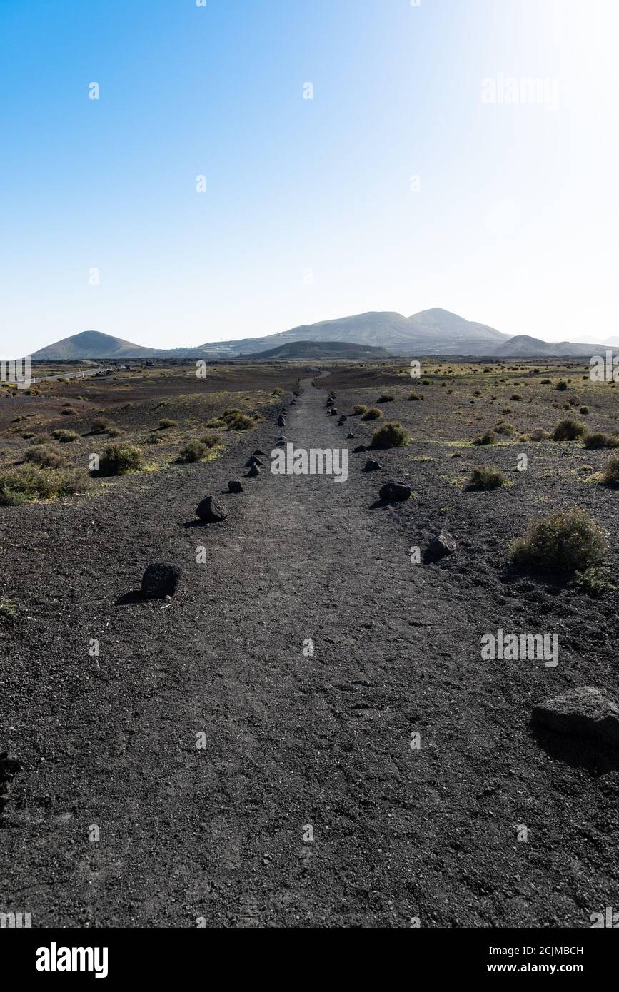 Percorsi di lava vulcanica a piedi e sentieri di trekking nel deserto vicino al parco dei vulcani Timanfaya. Lanzarote, Isole Canarie, Spagna. Concetto di viaggio Foto Stock