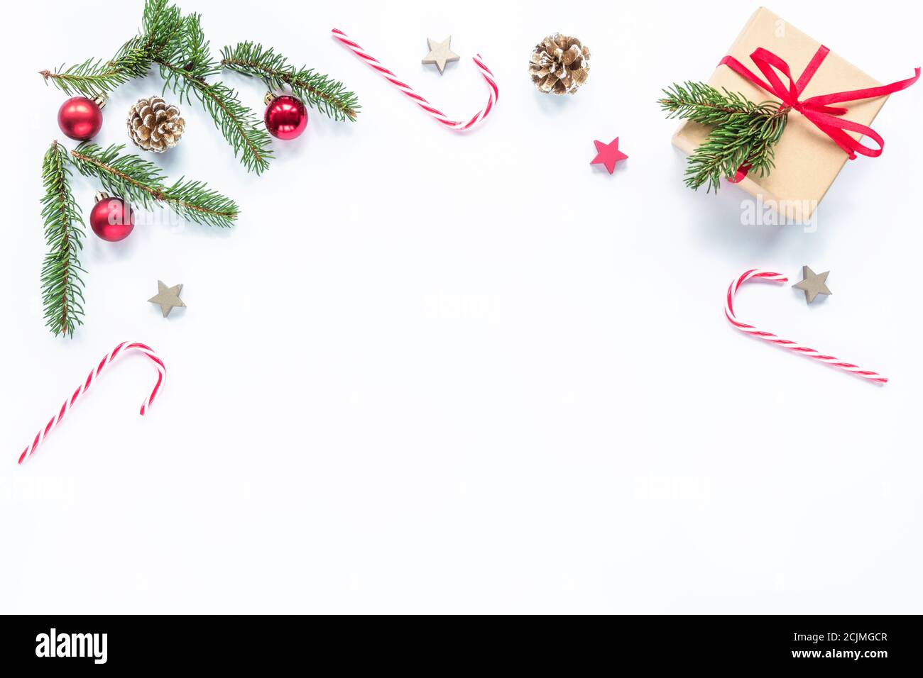 Cornice di Natale fatta di rami di abete, caramelle rosse, coni, decorazioni. Natale o Capodanno. Disposizione piatta, vista dall'alto, spazio per la copia. Foto Stock