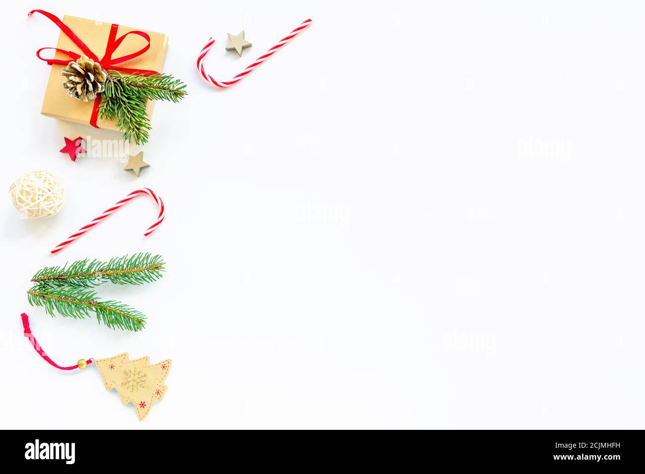 Disposizione di Natale fatta di rami di abete, caramella rossa, regalo in scatola, decorazioni. Natale o Capodanno. Disposizione piatta, vista dall'alto, spazio per la copia. Foto Stock