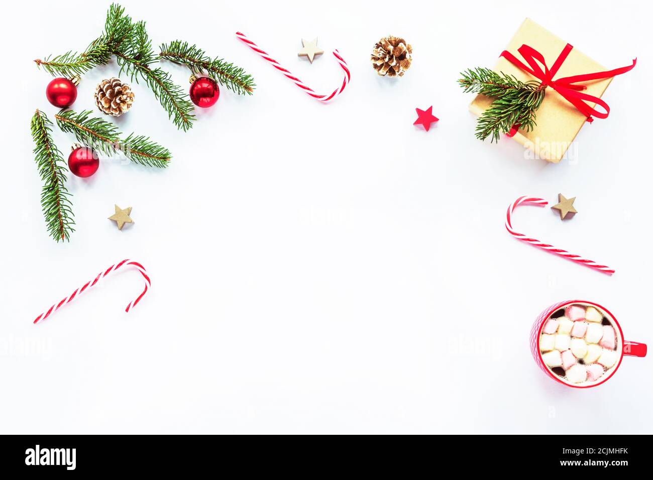Cornice natalizia fatta di rami di abete, caramelle rosse, coni, tazza di cacao con marmallows, decorazioni. Natale o Capodanno. Posa piatta, parte superiore vi Foto Stock