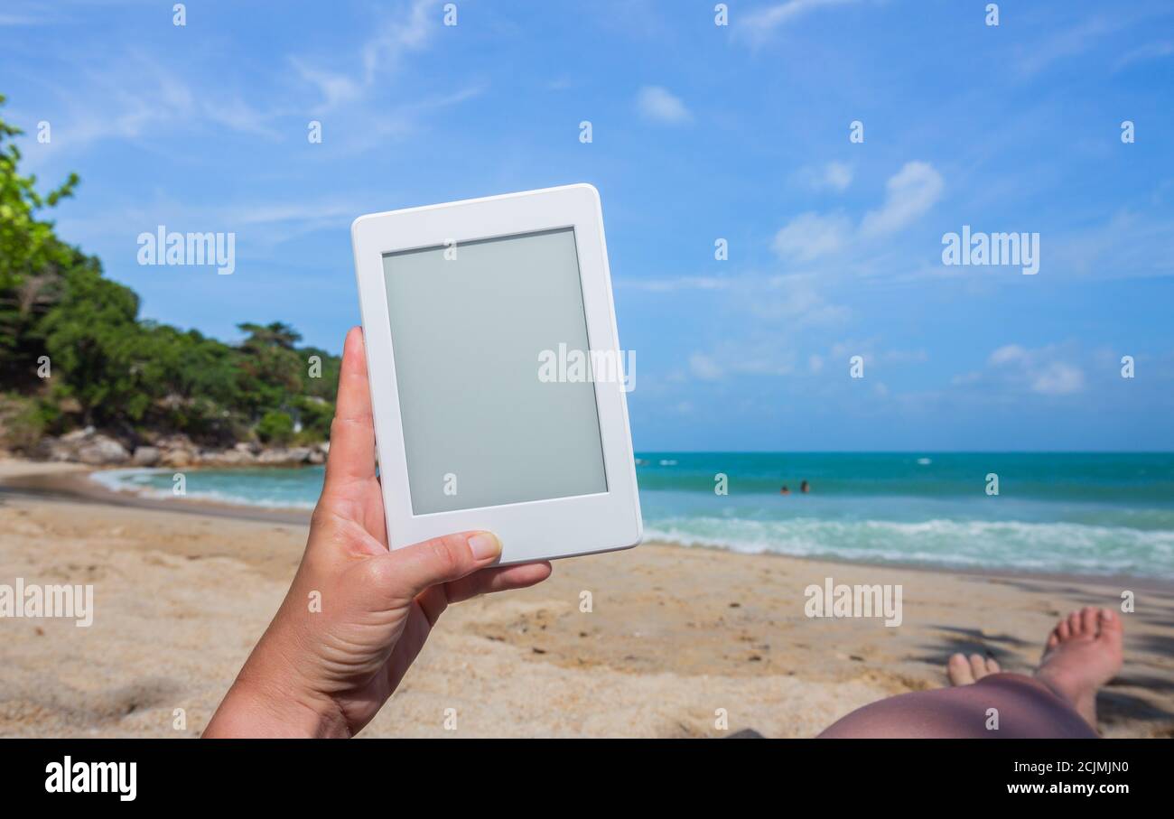 Mani con una tavoletta bianca su una spiaggia a ko Phangan, Thailandia Foto Stock
