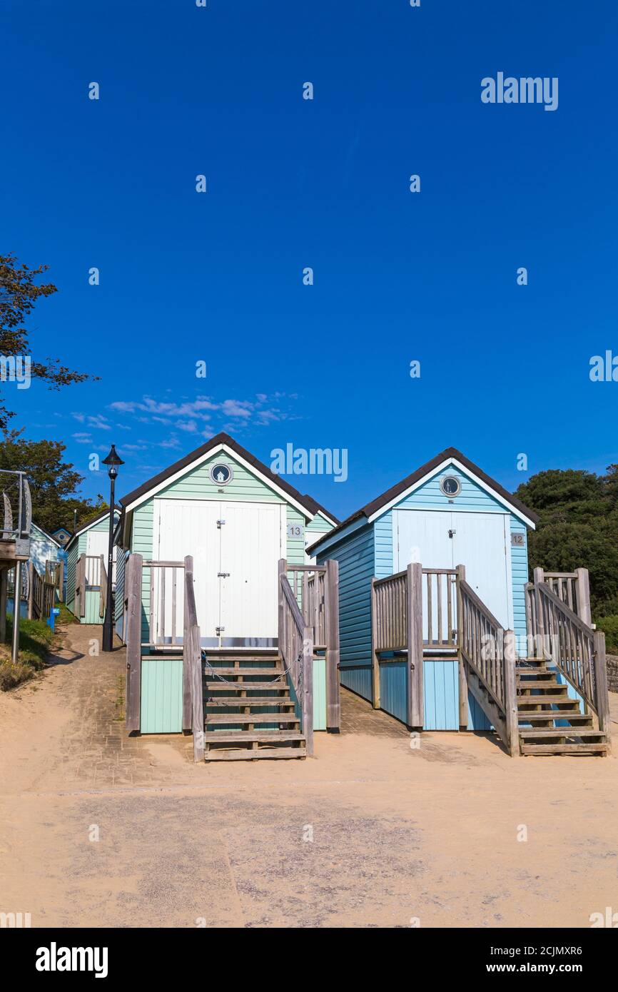 Nuvola bianca nel cielo blu sopra le capanne sulla spiaggia ad Alum Chine, Bournemouth, Dorset UK in caldo giorno di sole nel mese di settembre con mini onda di calore Foto Stock