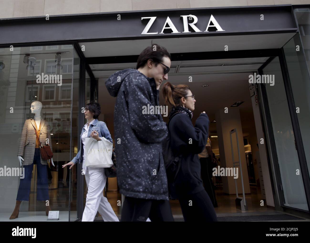 La gente passa accanto a un negozio Zara nel centro di Madrid, Spagna, 16  settembre 2015. Inditex, il più grande rivenditore di abbigliamento del  mondo, ha riferito un inizio di branconio alla