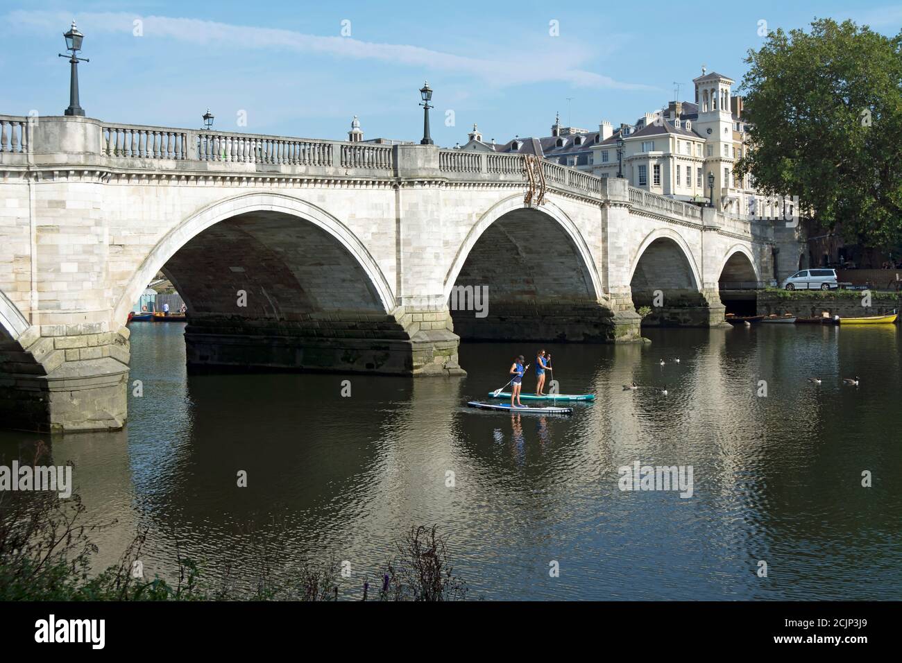 due donne paddle boarders sul fiume tamigi vicino a richmond bridge, a sud-ovest di londra, inghilterra Foto Stock