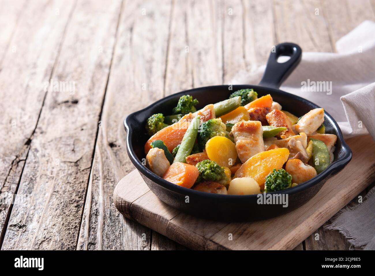 Mescolare il pollo fritto con le verdure su una padella di ferro su legno Spazio Table.Copy Foto Stock