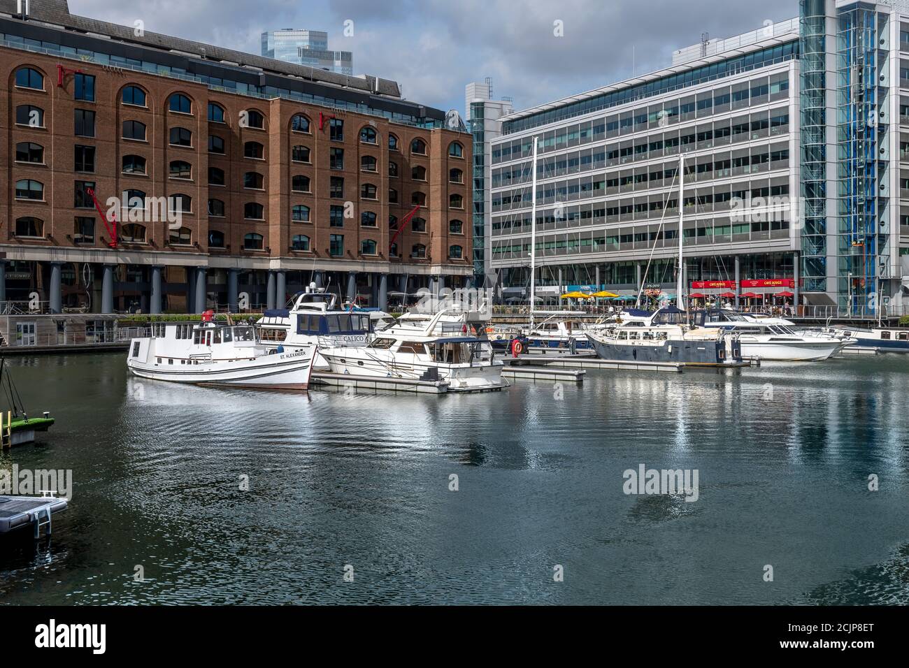 Molo di St Katherine vicino al Tower Bridge. Le banchine sono ora sede di yacht di lusso, piccole barche e motoscafi e circondati da caffè e bar. Foto Stock