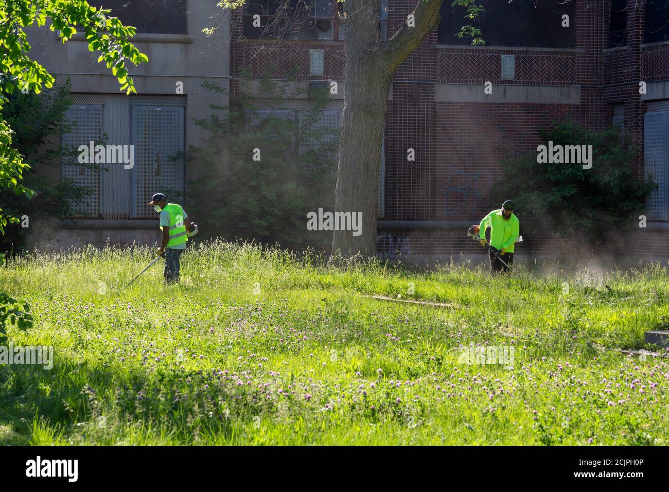 Detroit, Michigan - i lavoratori del Detroit Grounds Crew hanno tagliato l'erba sui terreni della Burbank School, una delle dozzine di scuole pubbliche chiuse i Foto Stock